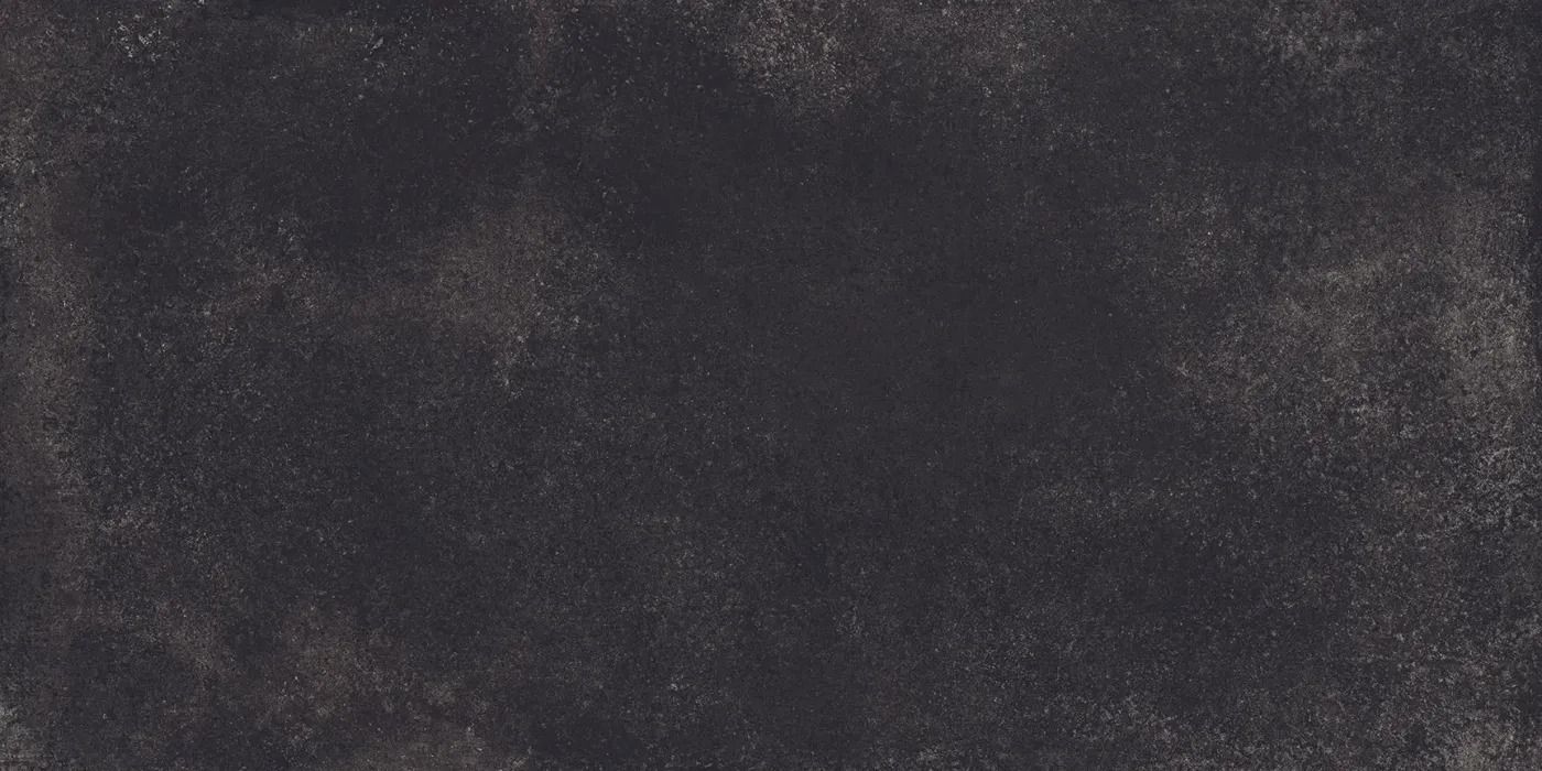 Dark, rough-textured black surface with subtle gray speckles and a weathered look