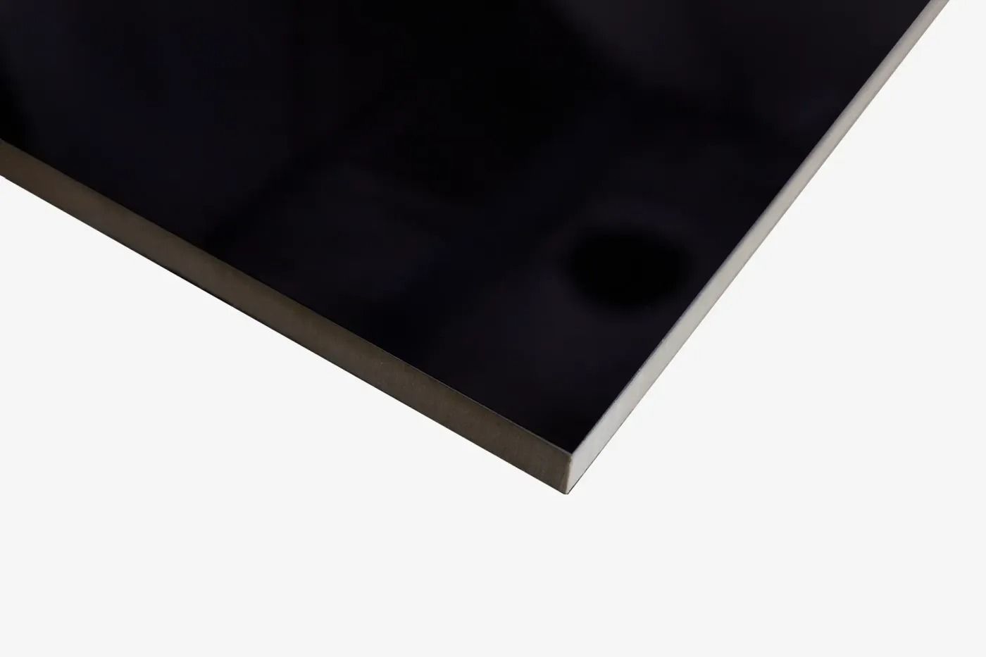 Close-up of a black rectangular device corner with a silver edge on a white background