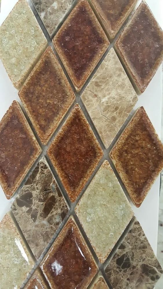 Rustic diamond-patterned ceramic tiles in beige, brown, and green tones on a wall