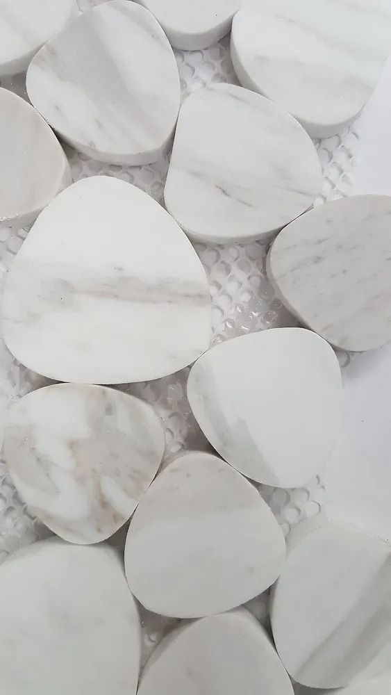 White marble teardrop-shaped stones with subtle gray veining, arranged closely together