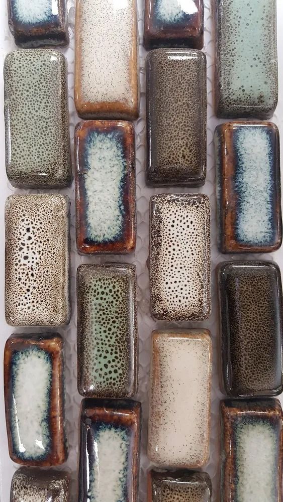 Close-up of glossy mosaic tiles in neutral tones of beige, brown, gray, and blue.
