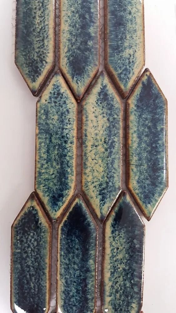 Vertical mosaic of blue and teal hexagonal tiles with gold outlines on a light background