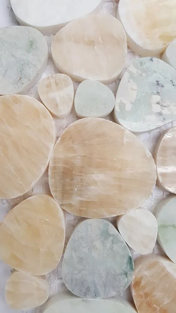 Close-up of overlapping translucent circular stones in beige, white, and pale blue tones