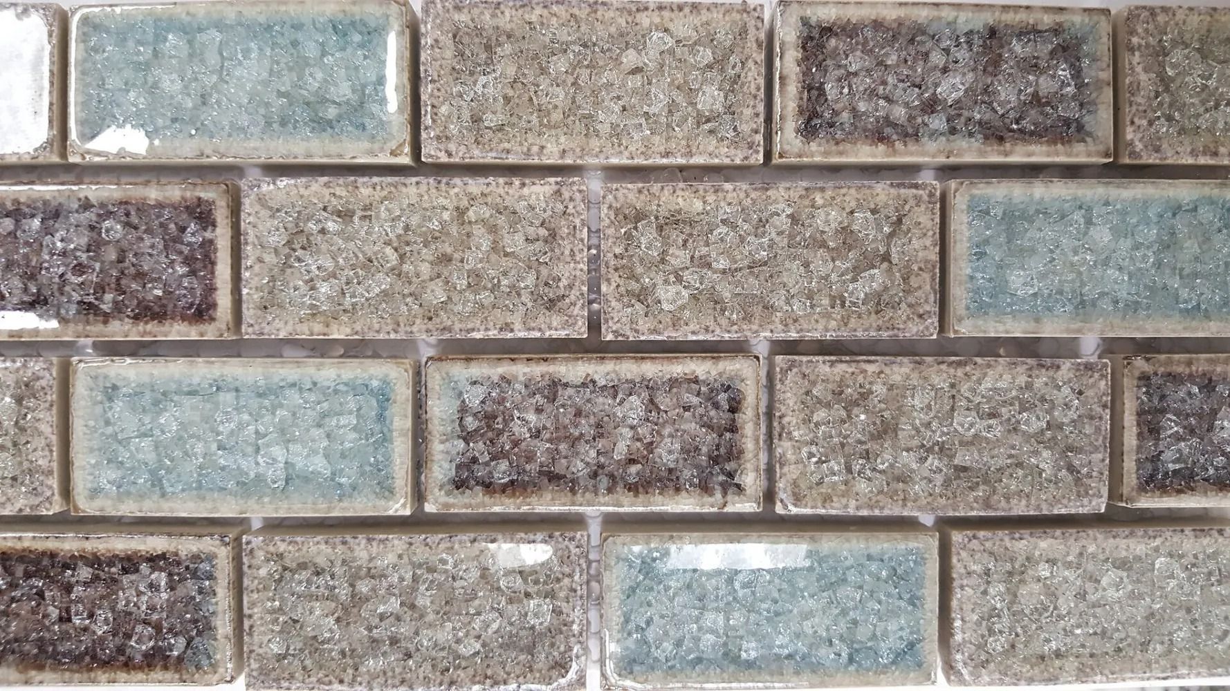 Gray and tan brick wall with rectangular textured stones in a staggered pattern