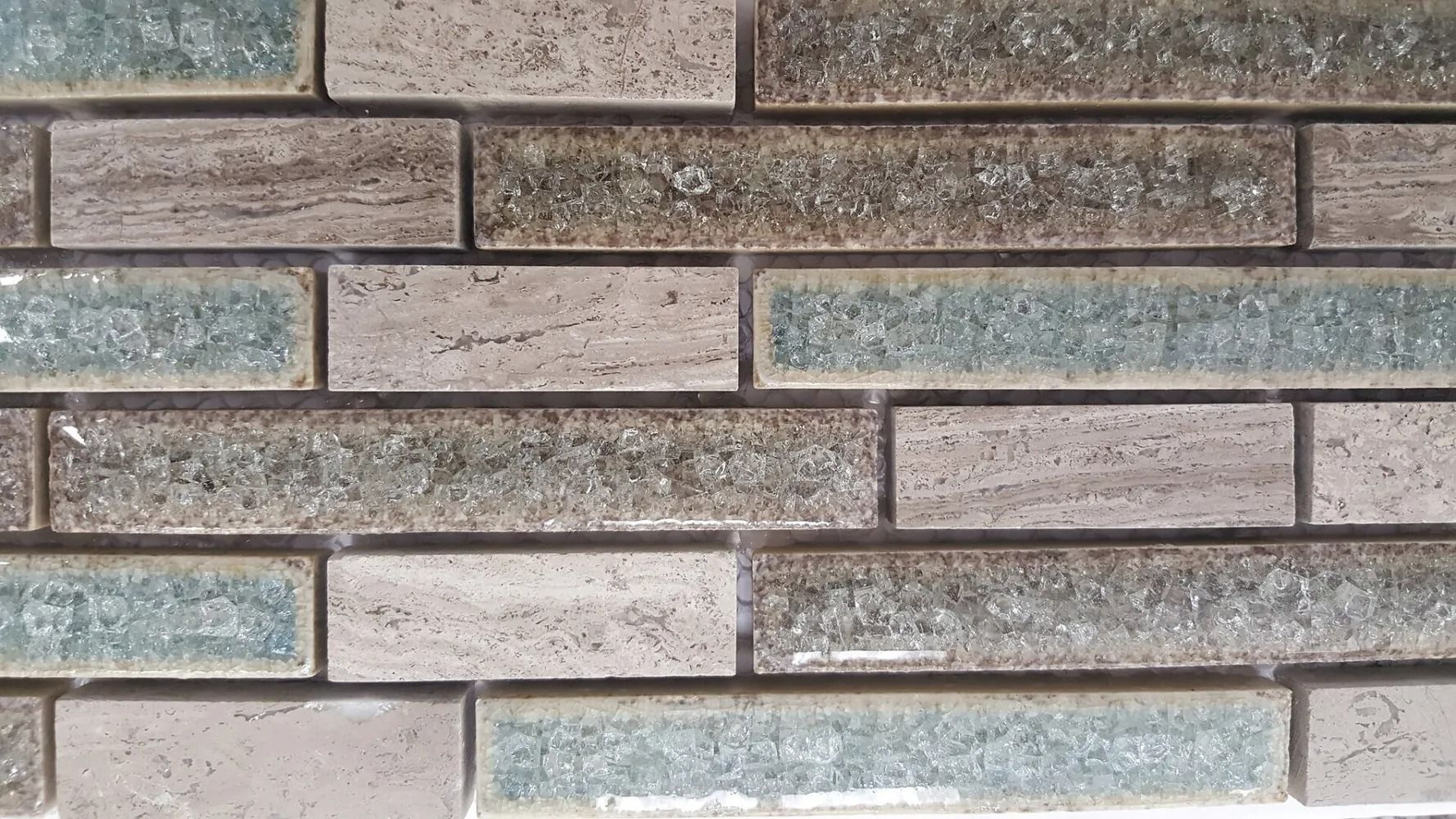 Close-up of stacked stone bricks in gray, tan, and light blue tones.
