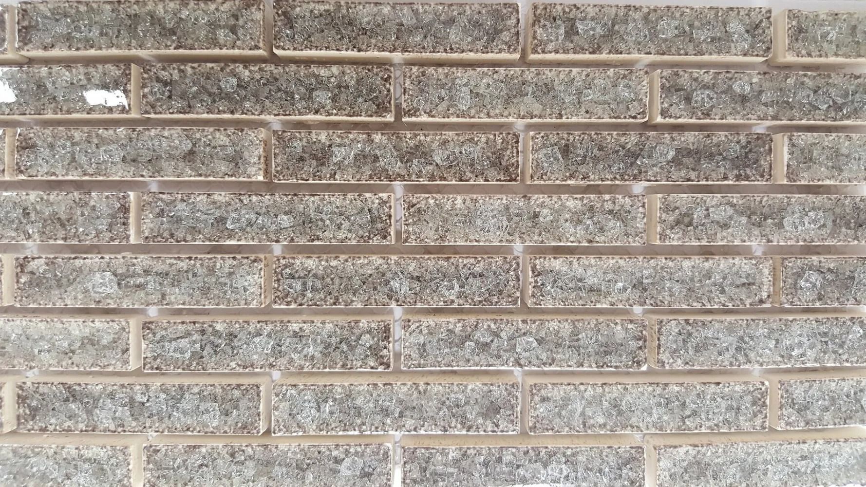 Close-up of a gray brick wall with tan mortar lines and weathered texture