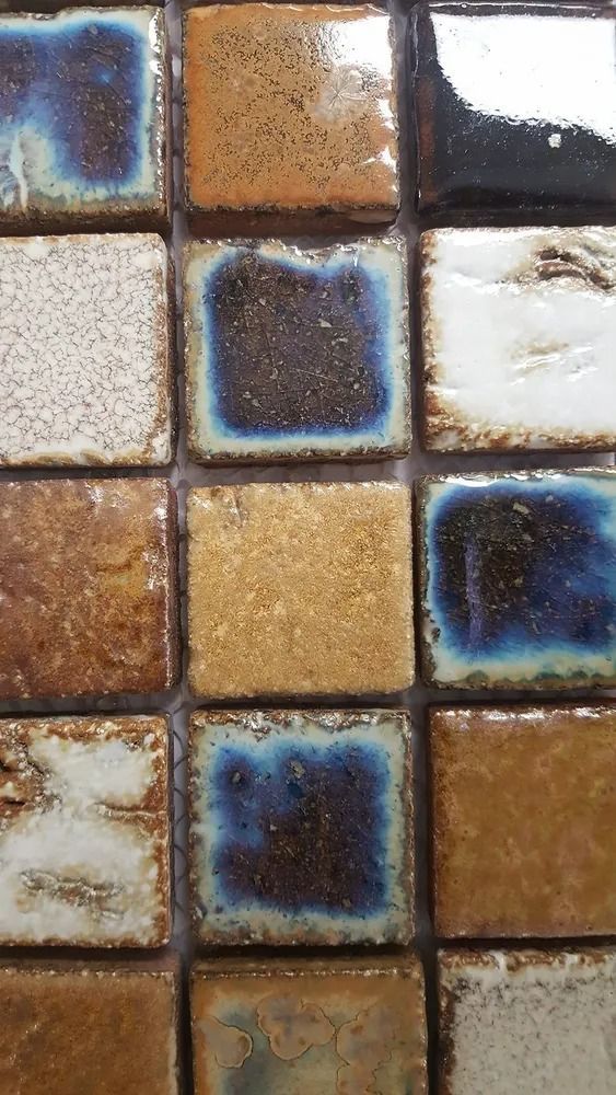 Close-up of a colorful mosaic tile wall with blue, brown, and white squares.