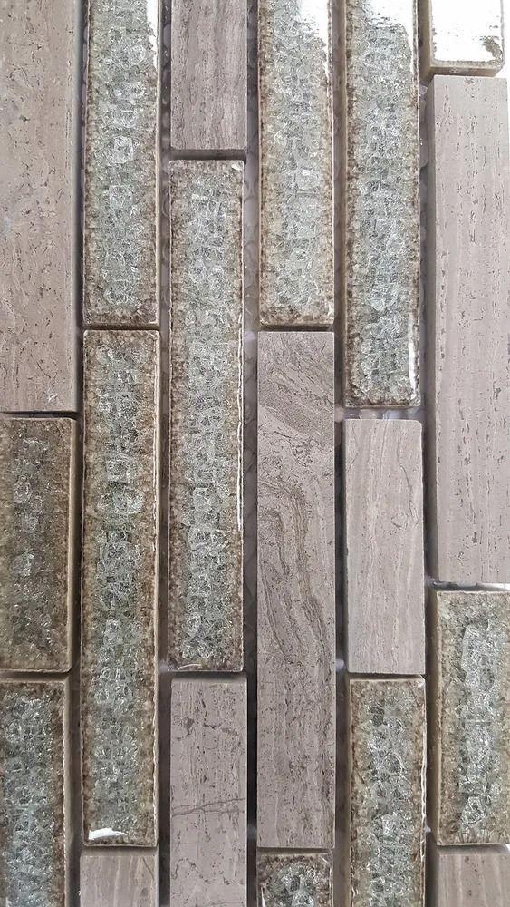 Vertical mosaic of narrow beige, gray, and green-speckled stone tiles