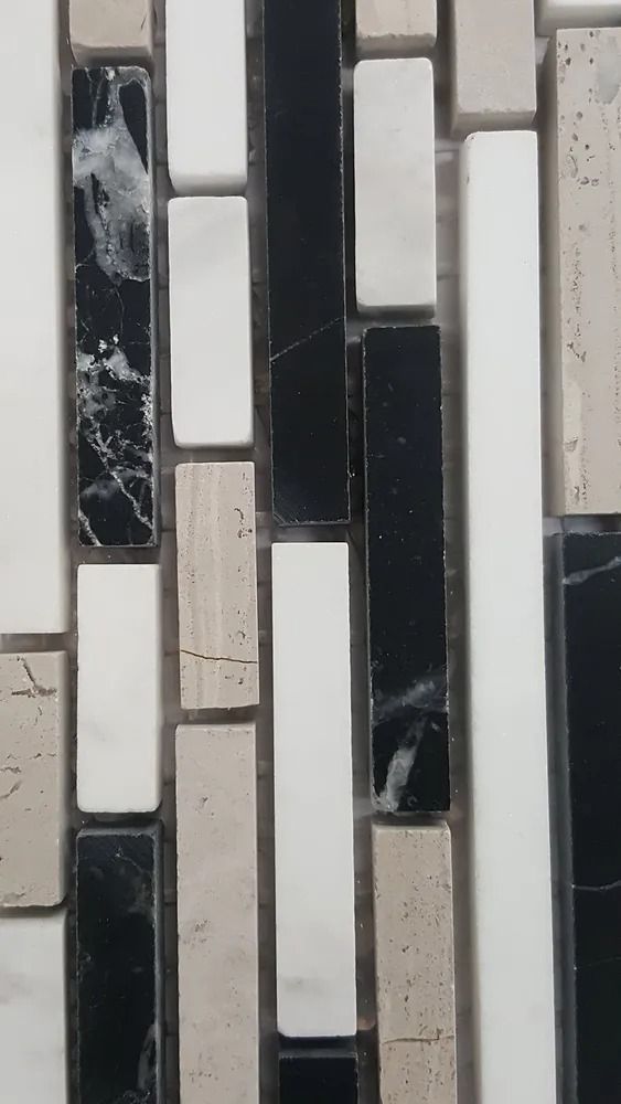 Black, white, and beige mosaic tile wall with narrow vertical rectangular pieces