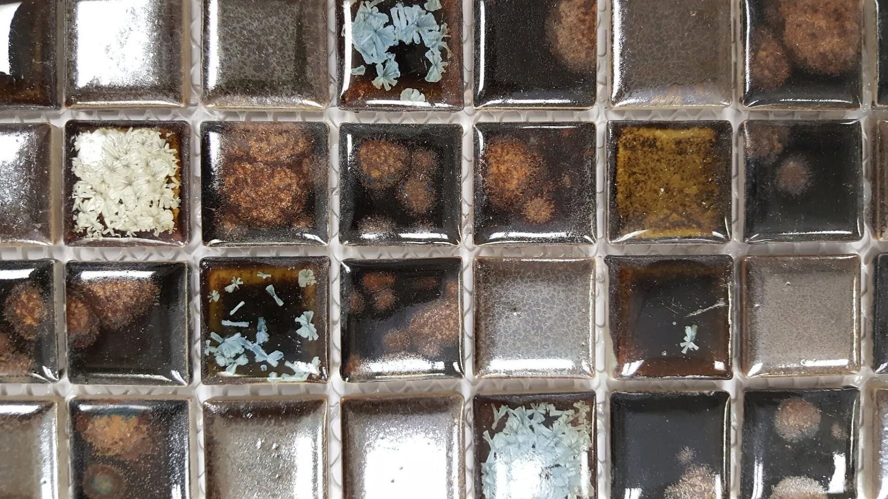 Close-up of a mosaic tile grid in brown, white, black, and blue-gray tones