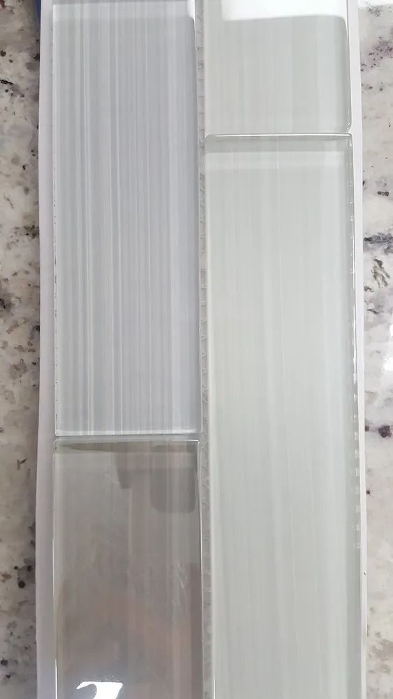Two tall frosted glass panels or windows, one with vertical stripes and one plain, in a neutral interior setting