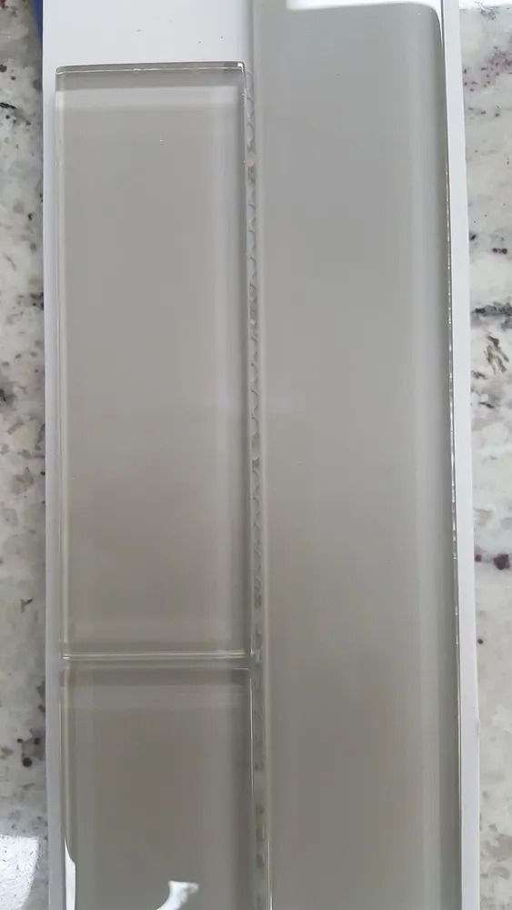 Two translucent plastic containers or cases standing side by side on a speckled countertop.