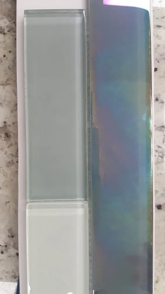 Two tall rectangular glass panels, one frosted gray and one iridescent blue-purple, side by side.