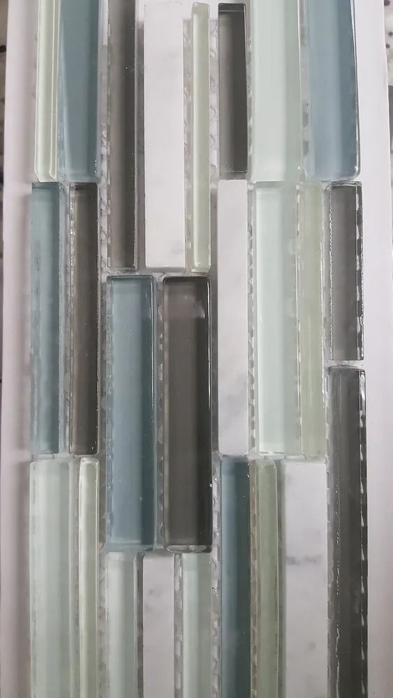 Vertical glass mosaic tiles in white, gray, and pale blue tones