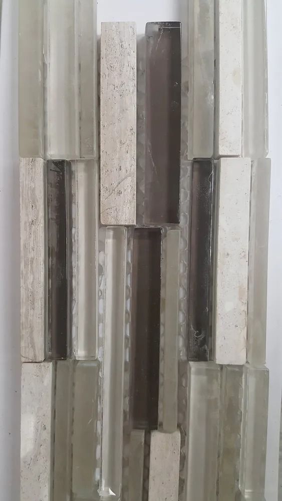 Vertical mosaic of metallic and glass tiles in silver, gray, and beige tones
