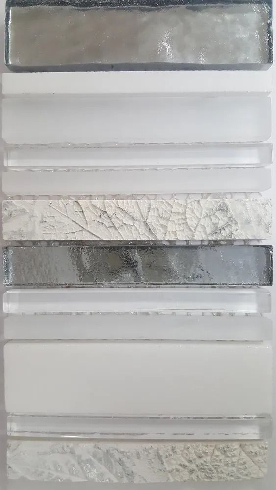 Stacked rectangular material samples in gray and white, showing different textures and patterns