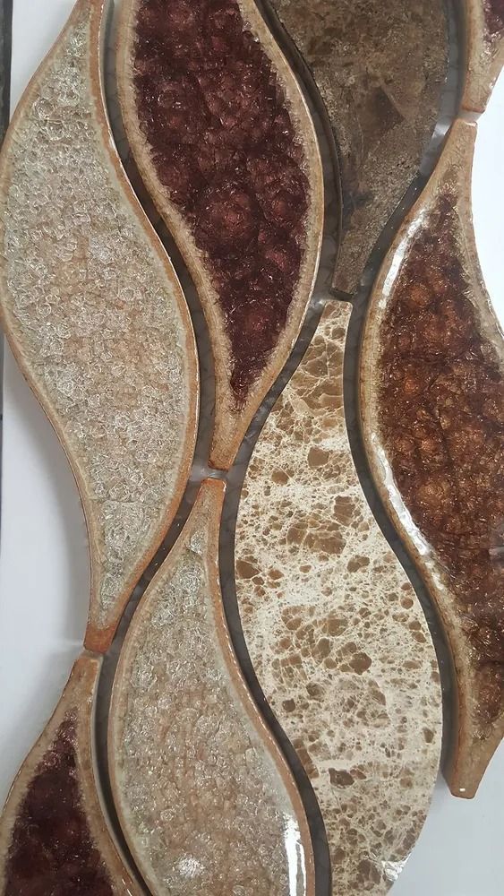 Close-up of textured decorative wall tiles in beige, brown, and gold wave patterns