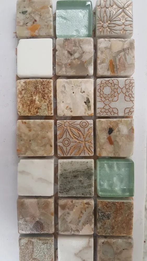 Sample of assorted beige, gray, and green patterned ceramic tiles arranged in a grid.