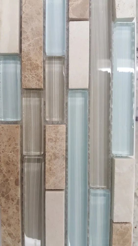 Vertical mosaic wall tiles in beige, gray, and pale blue glass and stone.