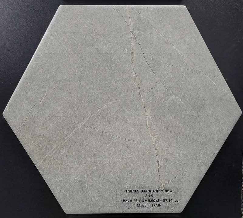 Hexagonal gray paper card with a vertical crease and small printed text near the bottom edge