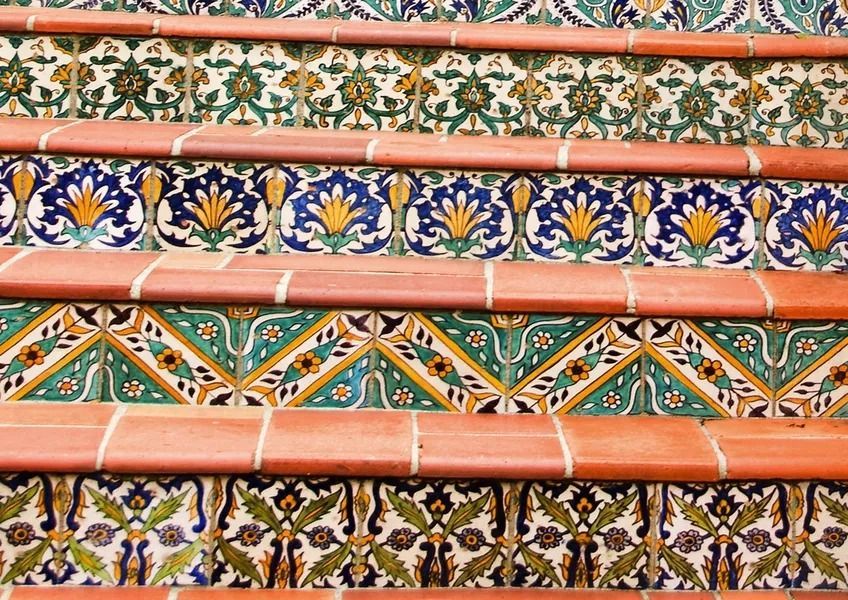 Colorful patterned ceramic staircase with terracotta steps and blue, green, and floral tile designs