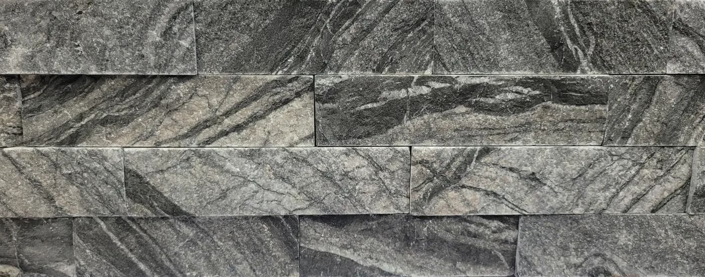 Gray stacked stone wall with varied rectangular slate tiles and textured patterns
