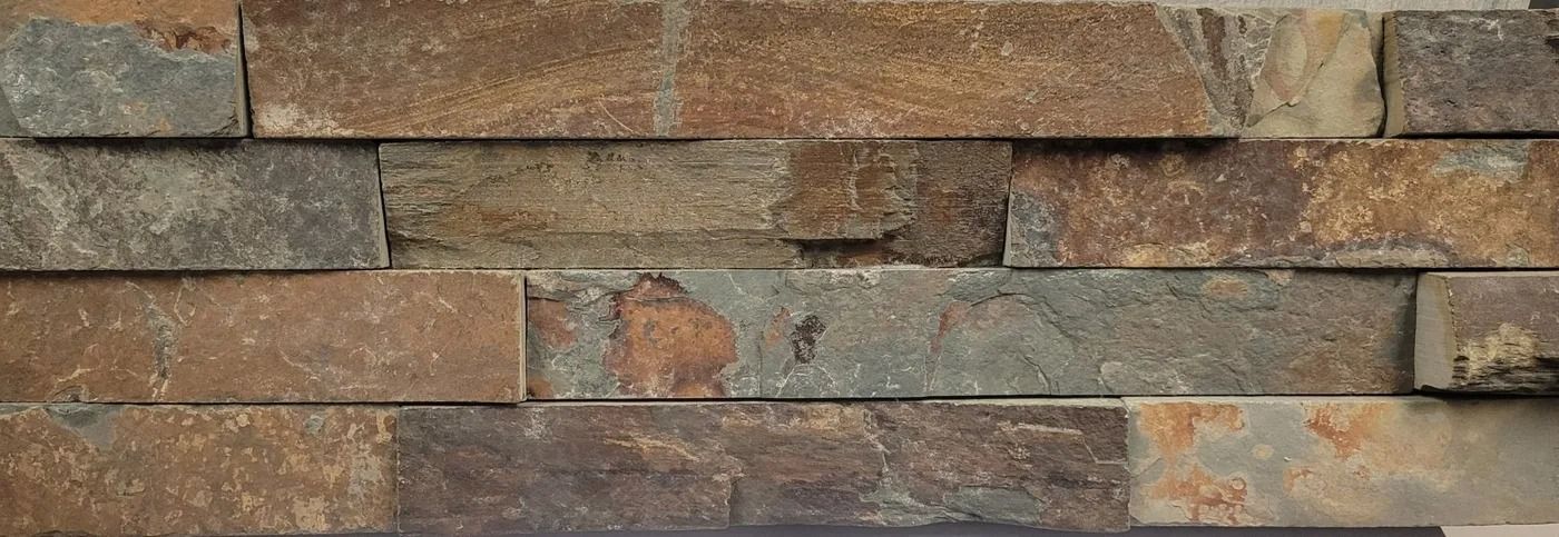 Close-up of a weathered brick wall with mixed brown, gray, and rust-colored bricks.
