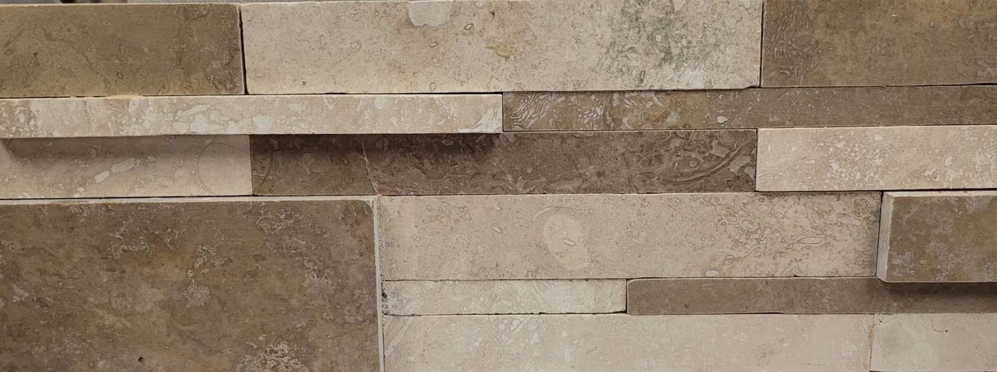 Tan and beige stacked stone wall with horizontal rectangular slabs and textured surfaces