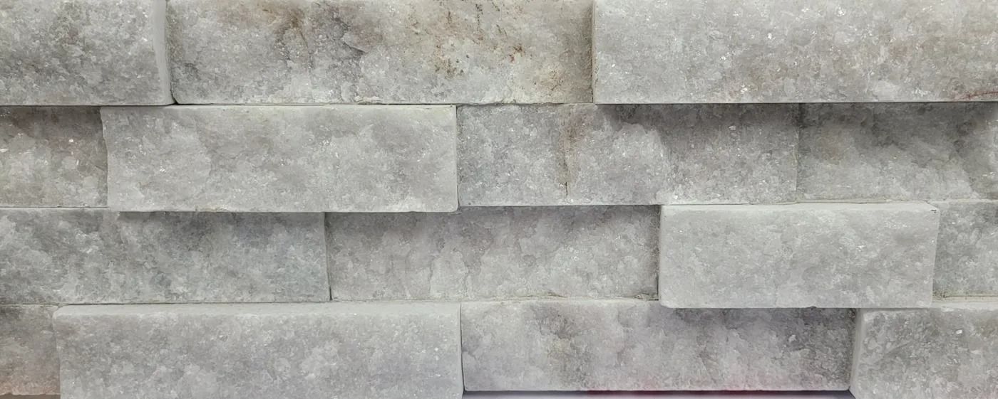 Gray stacked stone wall with rectangular blocks and varied textures