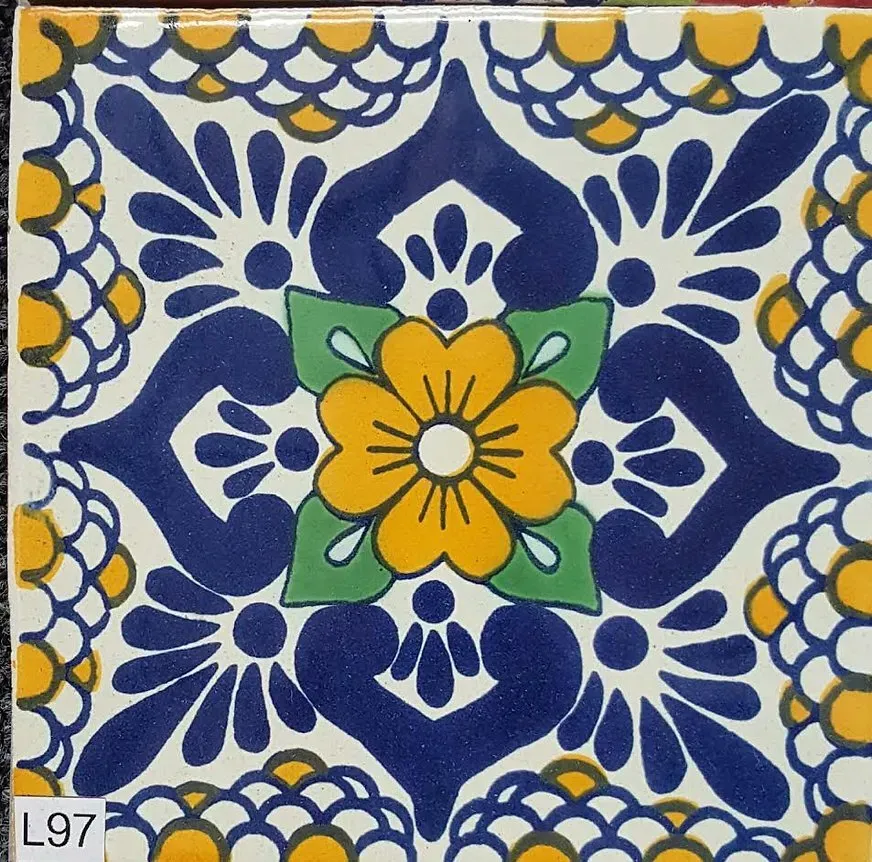 Blue-and-white floral tile with a yellow flower center and green accents