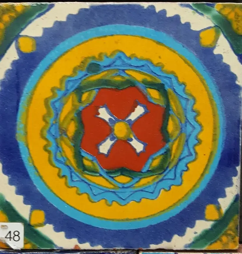 Colorful circular mandala with blue, yellow, red, and white concentric geometric patterns
