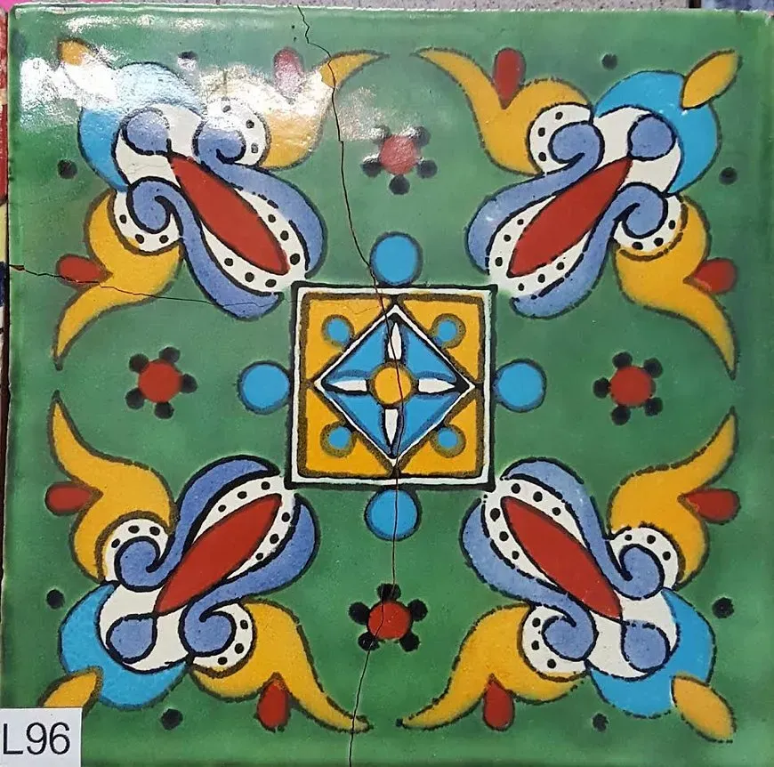 Colorful floral tile with blue, yellow, red, and green geometric pattern on a green background