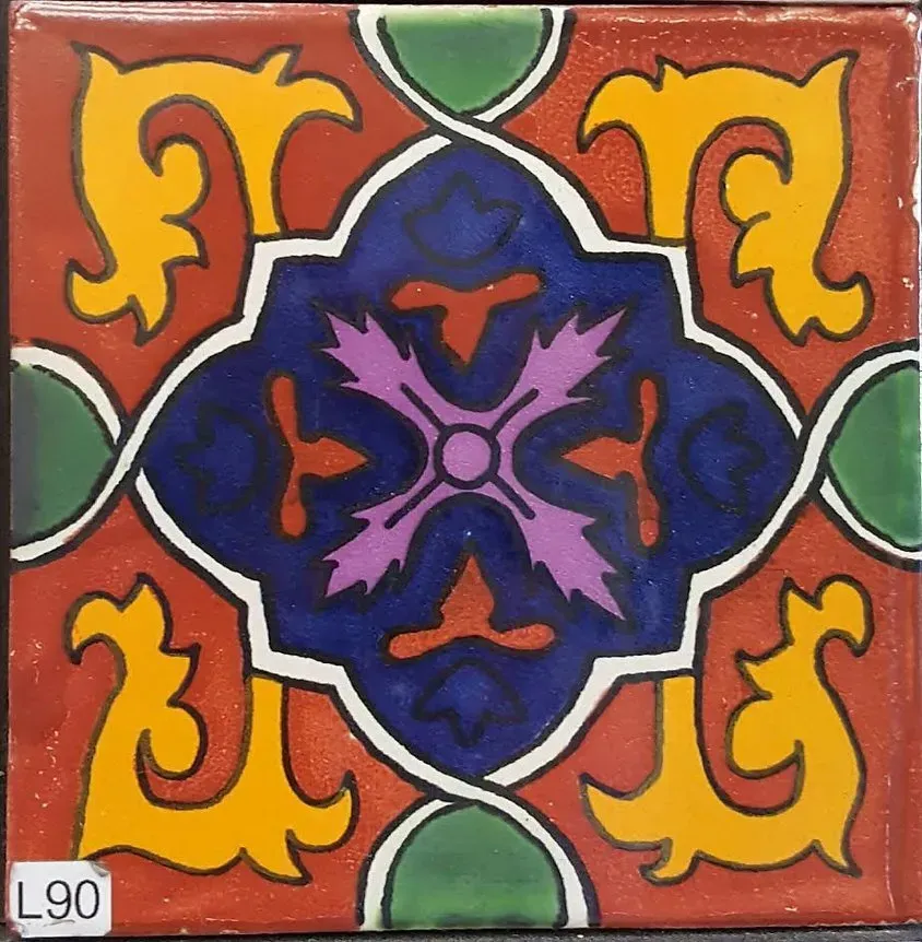 Colorful ceramic tile with symmetrical floral and geometric motifs in blue, red, yellow, and green