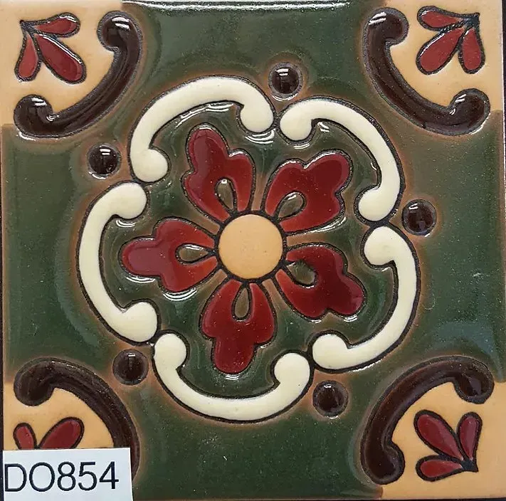 Decorative ceramic tile with green glaze, red floral motif, and cream scroll accents
