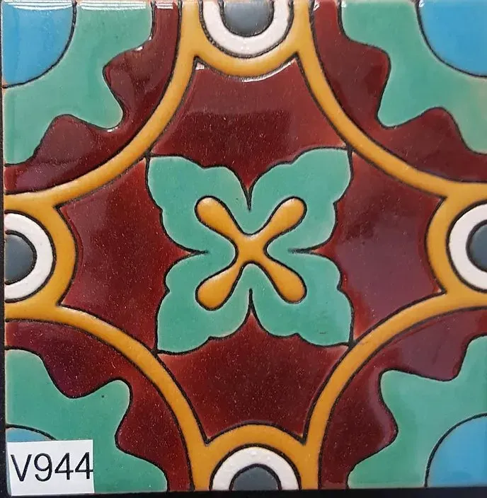 Colorful decorative tile with teal, maroon, gold, and white geometric floral patterns.