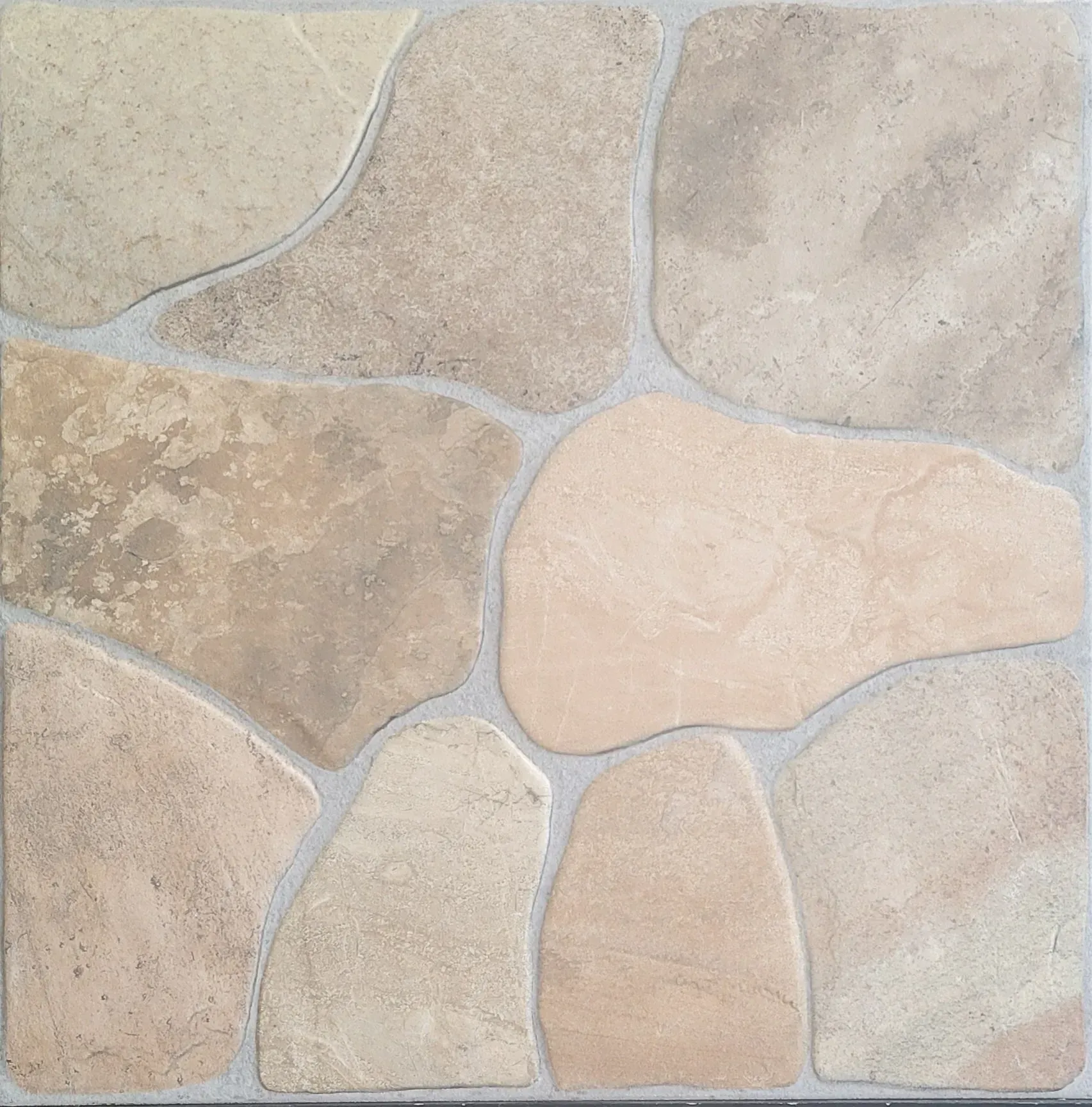 Close-up of beige and tan irregular stone tiles with light gray grout.