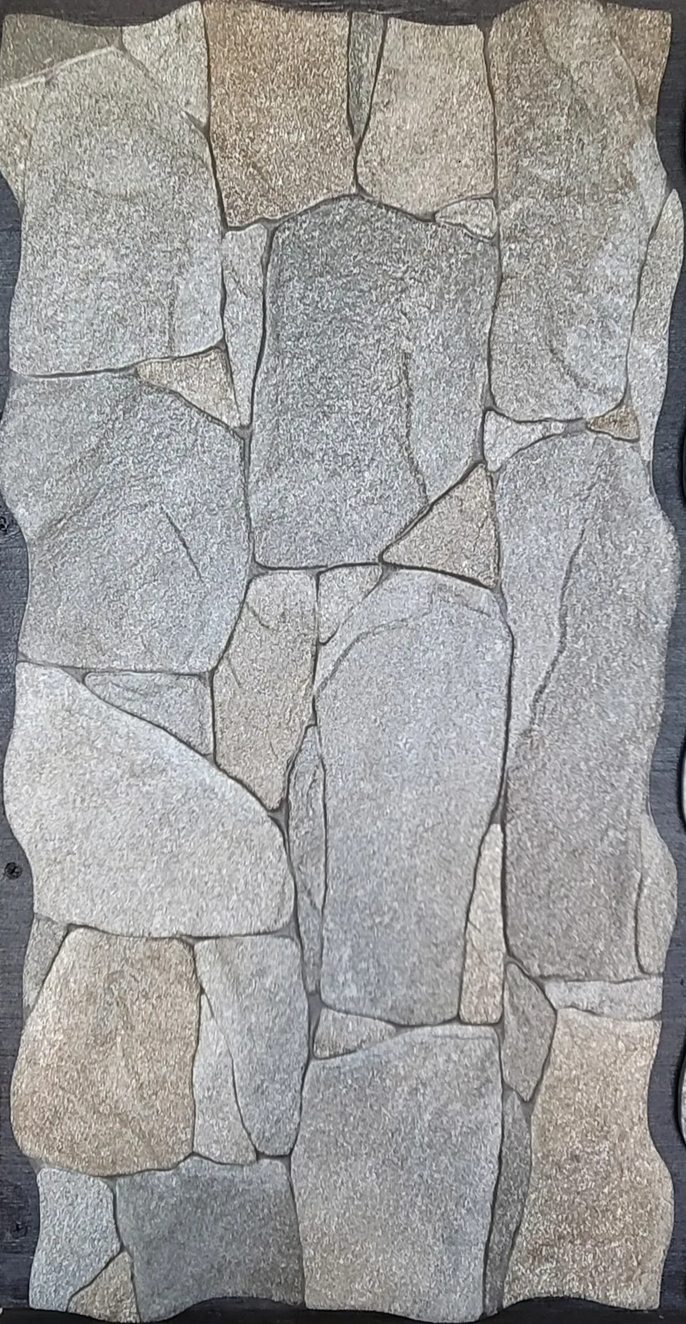 Close-up of a gray stone wall with irregular rectangular stones and dark mortar lines