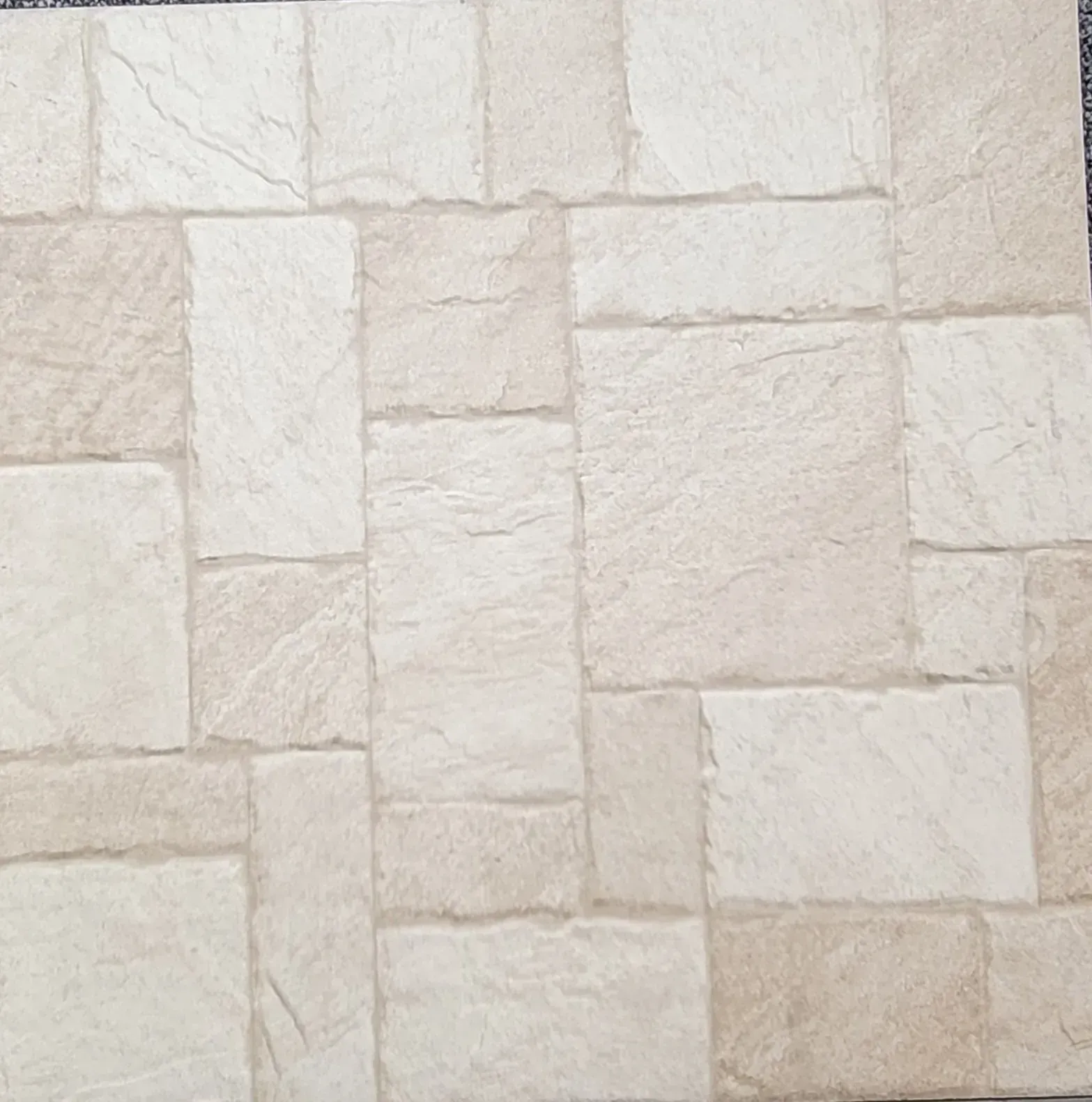 Light beige stone wall with rectangular tiles in a staggered pattern