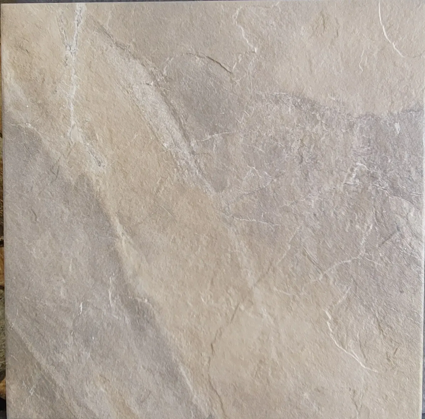 Beige stone tile with subtle white veining and a textured surface