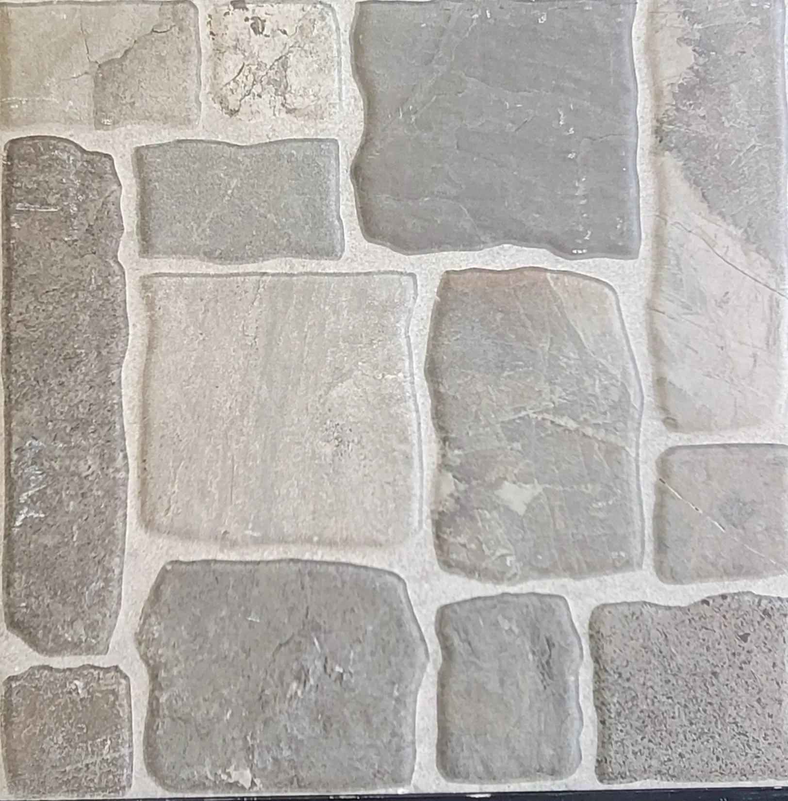 Gray and beige stone wall with irregular rectangular masonry blocks