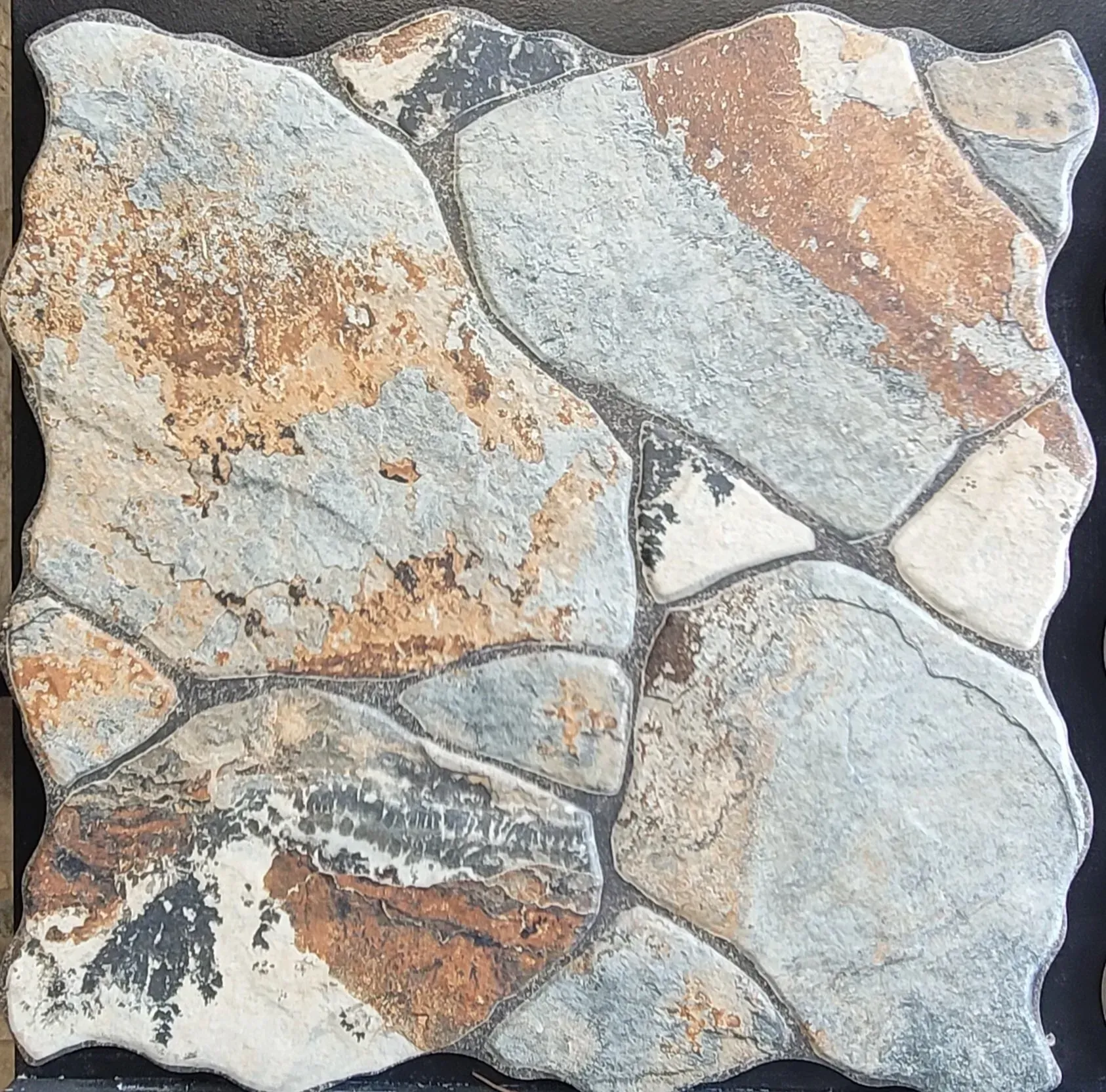 Square stone tile with irregular gray, tan, and rust-colored rock pattern