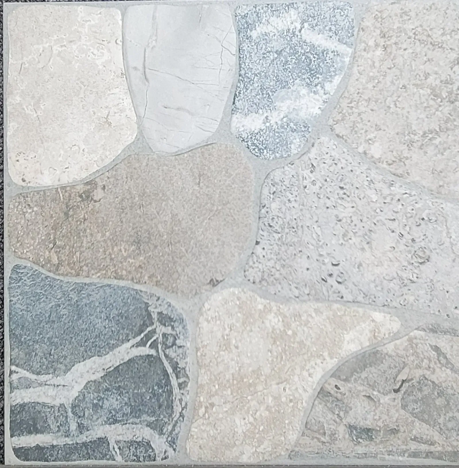 Close-up of pale gray and beige stone tile floor with irregular natural rock patterns