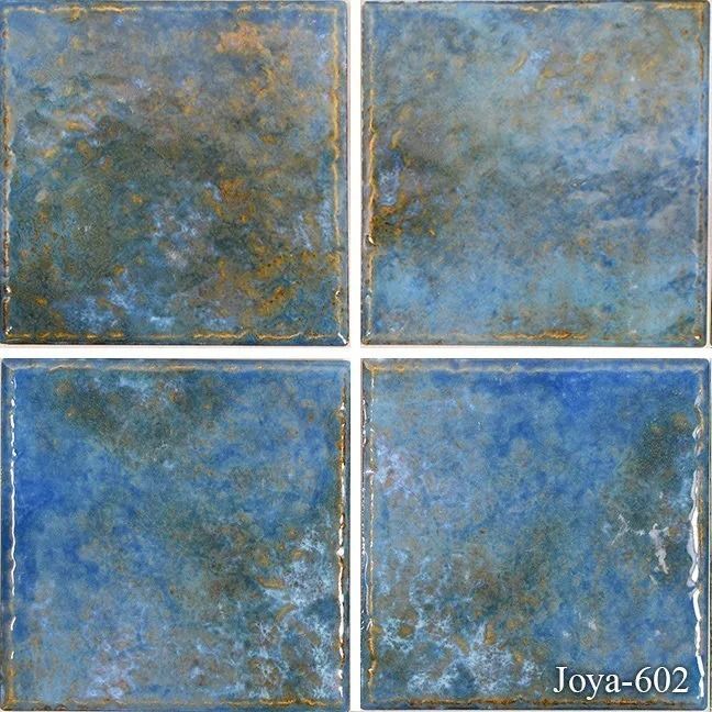 Four blue-gray textured square tiles arranged in a 2x2 grid with worn gold edges.