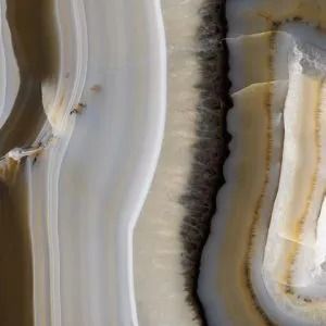 Close-up of layered beige, white, and gray agate bands with a dark central seam