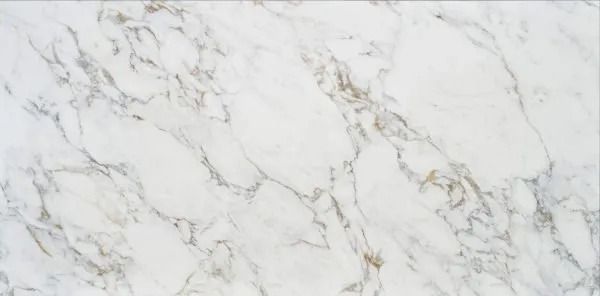 White marble surface with soft gray veining and subtle gold accents