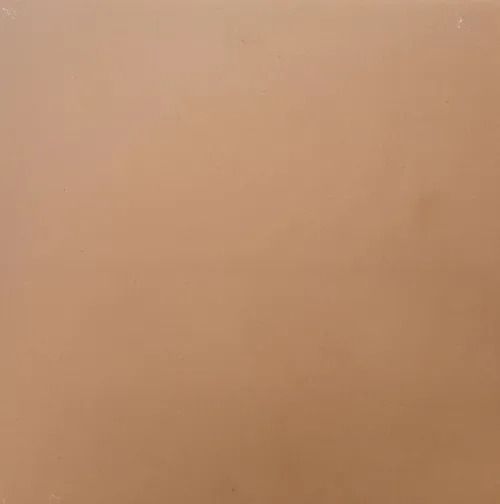 Plain tan wall with subtle shadows and a small dark speck near the bottom.