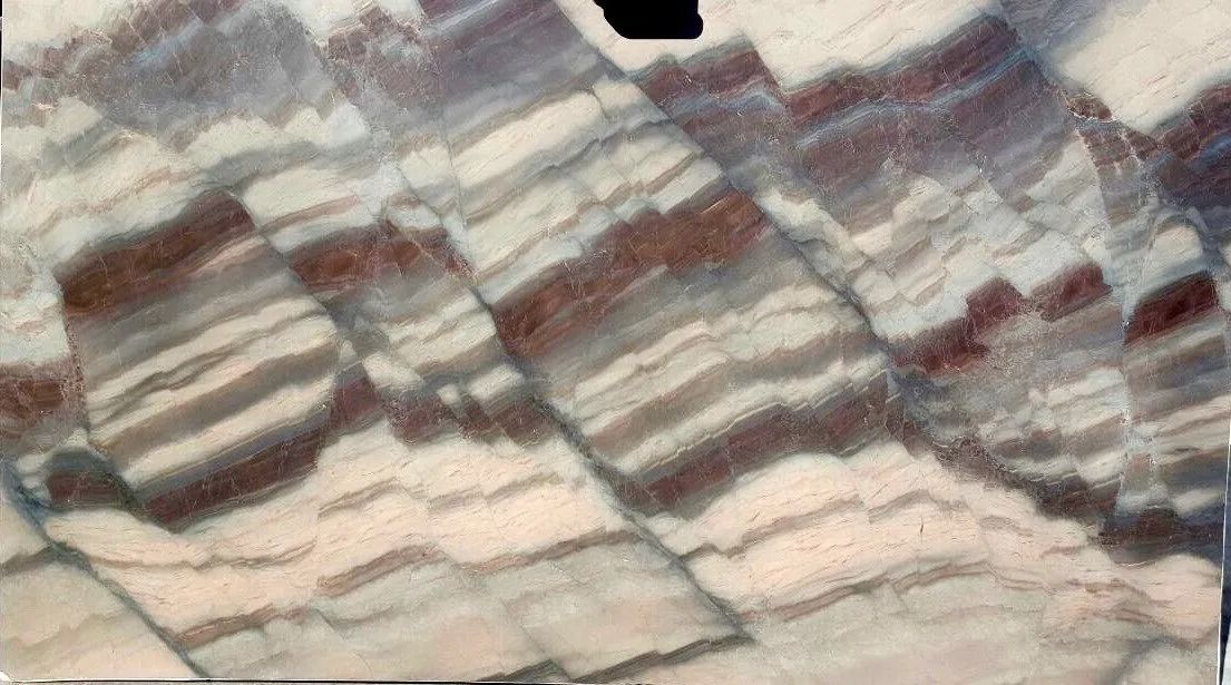 Close-up of layered striped rock with beige, gray, and reddish bands and rough texture