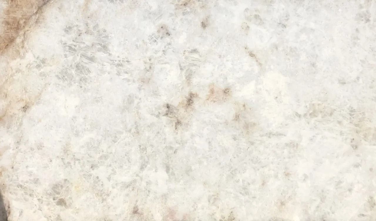 White and beige marble or stone surface with faint natural veining and speckled texture