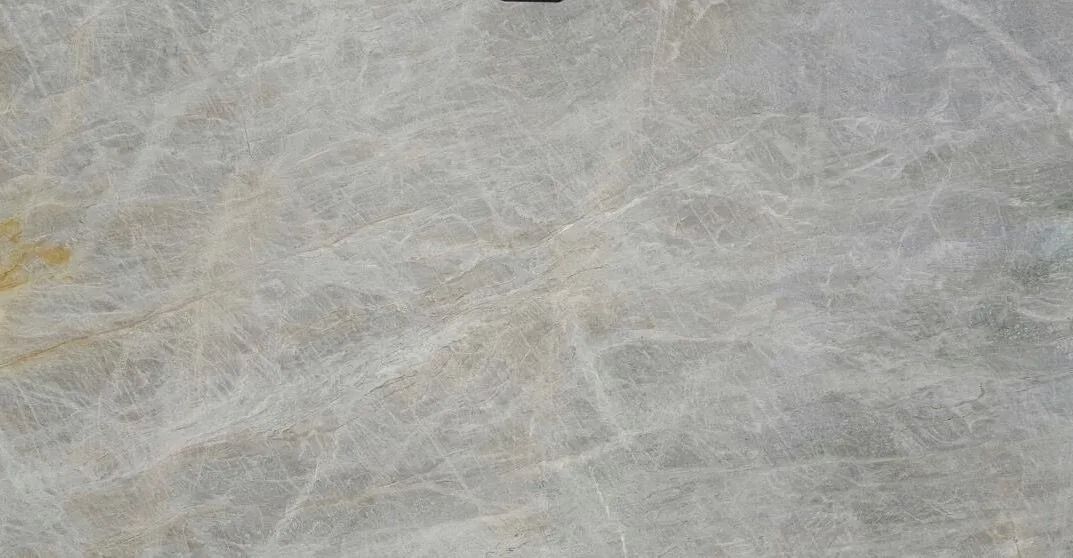 Close-up of a gray, white, and pale yellow stone or marble surface with subtle veining.