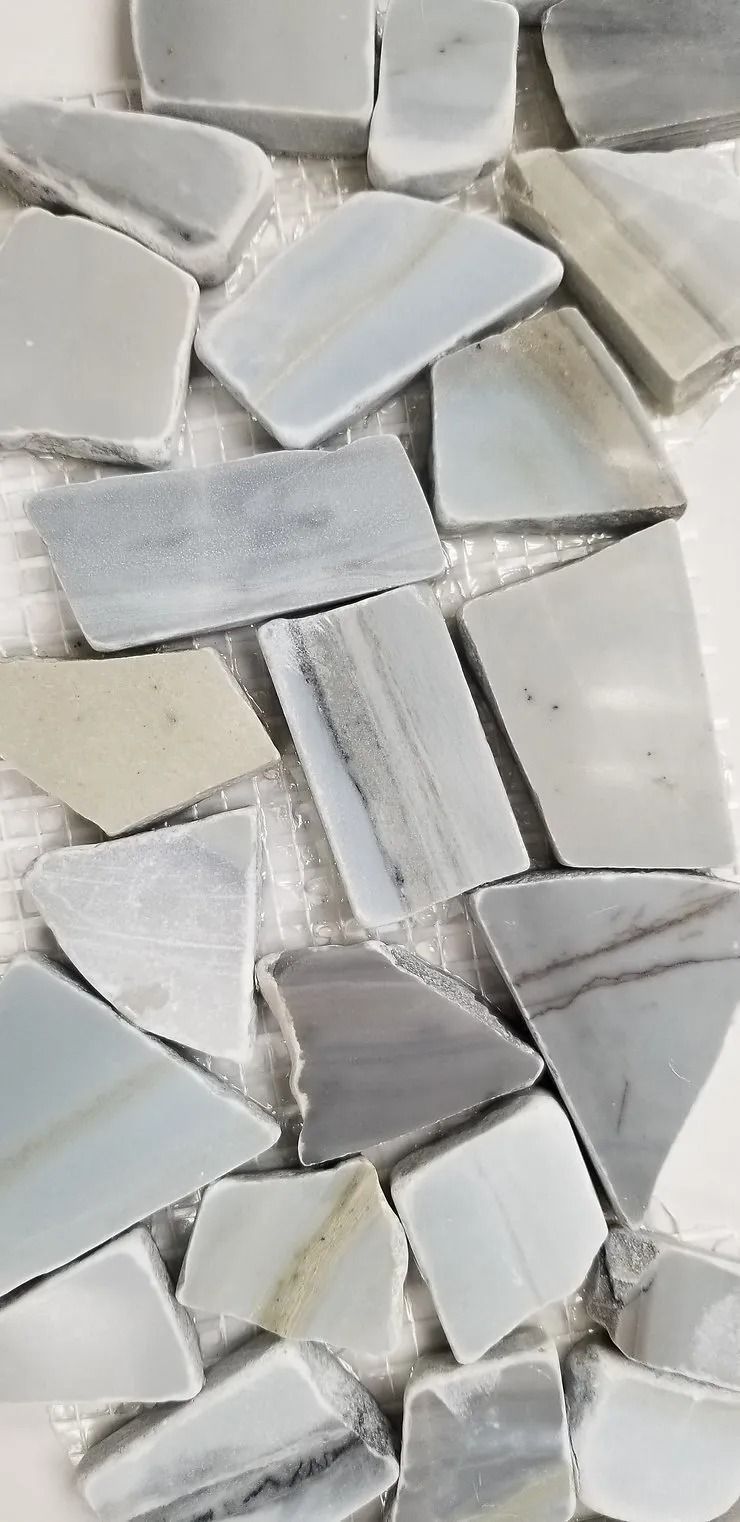 Close-up of light gray and white geometric stone or tile pieces arranged in a mosaic pattern